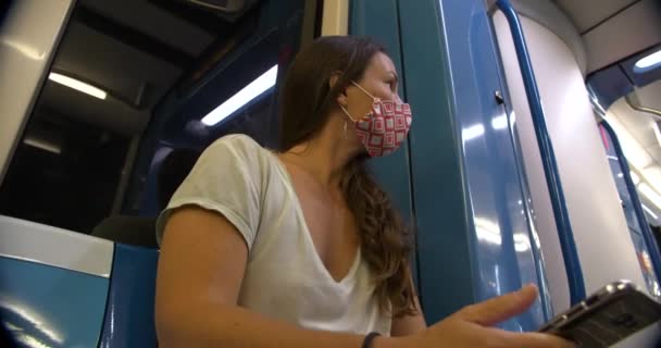 Vrouw met masker in de metro met telefoon — Stockvideo