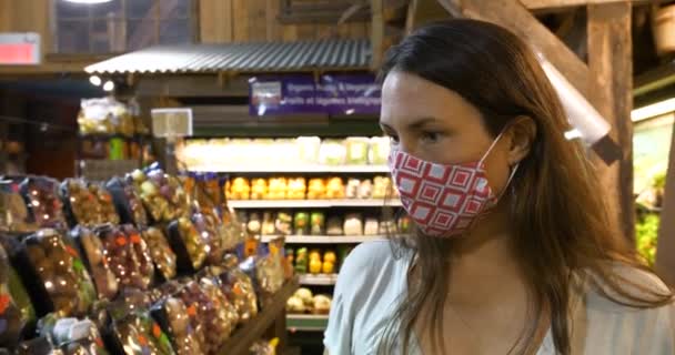 Kvinde iført maske ser på grøntsager – Stock-video