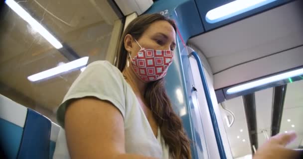 Vrouw met masker in de metro met behulp van smartphone — Stockvideo