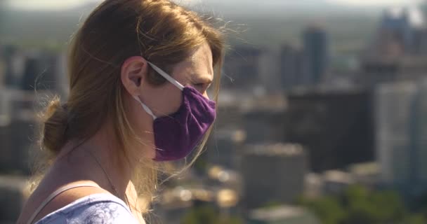 Mujer enmascarada sola mirando el paisaje de la ciudad — Vídeo de stock