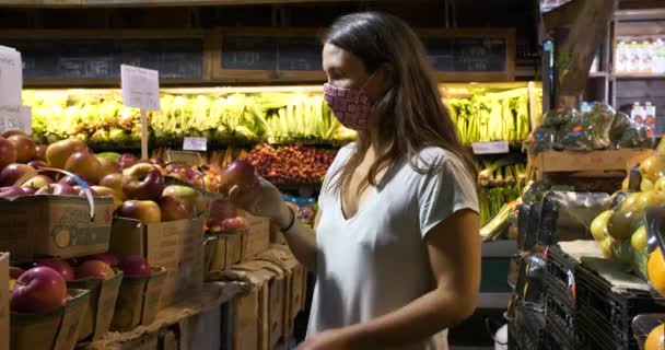 Młoda kobieta w masce kupuje świeże owoce — Wideo stockowe