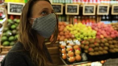 Markette maske takan tramvaylı bir kadın.