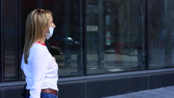 Jonge vrouw met gezichtsmasker en tas lopen — Stockvideo
