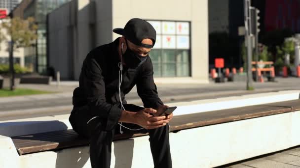 Hombre escuchando música por teléfono con auriculares — Vídeos de Stock