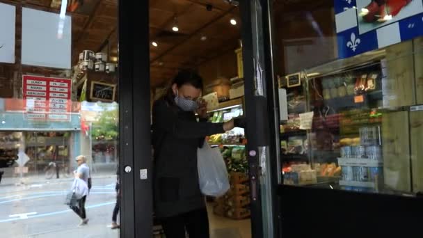 시장을 나오면서 마스크를 벗고 있는 여자 — 비디오
