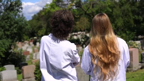 Two woman in cemetery talking seeing around — Stock Video