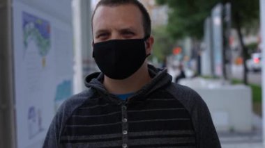 Asfaltta maske takan bir erkek.