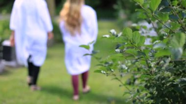 Mezarlıkta taze bitkiler ve yürüyen bir kadın.