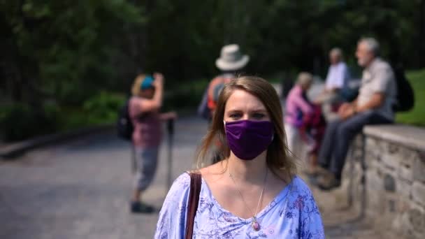 Weibchen mit Mundschutz und Tragetasche gehen — Stockvideo
