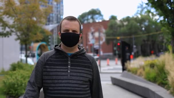 Mann mit Maske läuft durch Stadt — Stockvideo