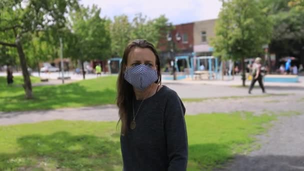 Kvinna bär mask promenader i parken — Stockvideo