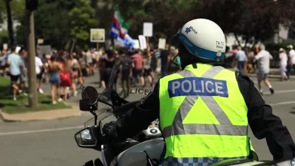 Policie sedí na kole a dívá se na protest — Stock video