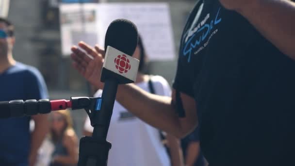 Людина дає інтерв'ю через мікрофон під час протесту — стокове відео