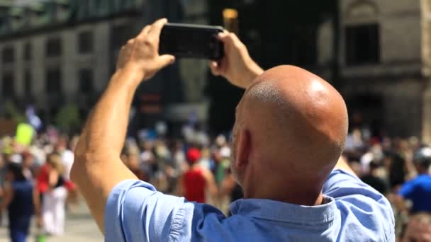 Mann mit Glatze filmt Protest per Handy — Stockvideo