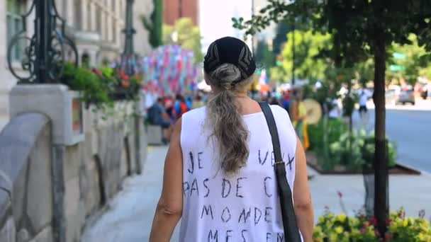 Женщина ходит с протестным текстом на одежде — стоковое видео