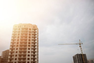 Büyük vinç ve bina inşaatı. Birçok yüksek binaların yapım aşamasında ve mavi gökyüzü altında vinçler için içinde yer