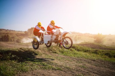 A picture of a biker doing a trick, and jumping into the air.Motocross Championship. sports fast driving. bike large small. clipart