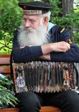 05.09.2012, Moscow, Rusya Federasyonu. Zafer Bayramı kutlamalarının Moskova. İkinci Dünya Savaşı gazisi kapatın. Denizci parkta bankta oturmuş bir akordeon ile.