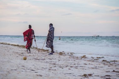 2018.02.21, Kiwengwa, Tanzanya. Tanzanya seyahat. Okyanus arka plan üzerinde duran iki etnik adam. İnsanlar sahilde.