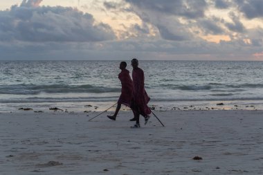 2018.02.21, Kiwengwa, Tanzanya. Tanzanya seyahat. Okyanus arka plan üzerinde duran iki etnik adam. İnsanlar sahilde.