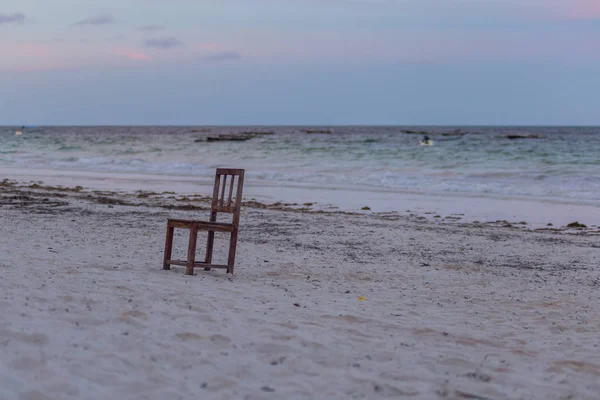 A single chair on the beach. Seascape with chair. Travel around Tanzania.