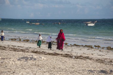 2018.02.21, Kiwengwa, Tanzanya. Bir grup genç insan sahilde yürüyüş. Öğrenciler eve gidiyor. Çocuklar eve gidiyor.