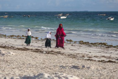 2018.02.21, Kiwengwa, Tanzanya. Bir grup genç insan sahilde yürüyüş. Öğrenciler eve gidiyor. Çocuklar eve gidiyor.