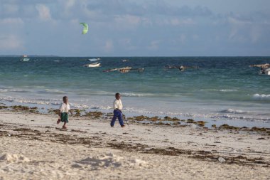 2018.02.21, Kiwengwa, Tanzanya. Bir grup genç insan sahilde yürüyüş. Öğrenciler eve gidiyor. Çocuklar eve gidiyor.