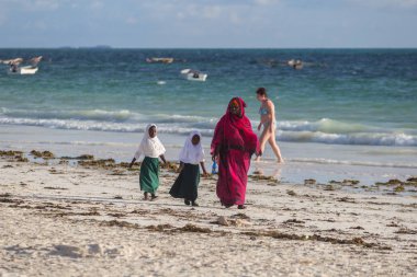 2018.02.21, Kiwengwa, Tanzanya. Bir grup genç insan sahilde yürüyüş. Öğrenciler eve gidiyor. Çocuklar eve gidiyor.