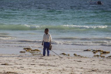 2018.02.21, Kiwengwa, Tanzanya. Tanzanya seyahat. Kıyı boyunca çalışan çocuk. Sahilde insanlar. Tanzanya okullu çocuk.