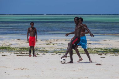 2018.02.21, Kiwengwa, Tanzanya. Tanzanya seyahat. Arka plan mavi gökyüzü ve okyanus plaj futbol oynamak çekici bir Afrika erkek.