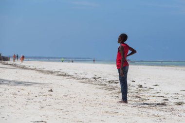 2018.02.21, Kiwengwa, Tanzanya. Tanzanya seyahat. Arka plan mavi gökyüzü ve okyanus plaj üzerinde duran bir çekici Afrika erkek.