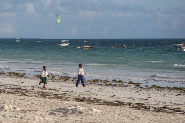 2018.02.21, Kiwengwa, Tanzanya. Bir grup genç insan sahilde yürüyüş. Öğrenciler eve gidiyor. Çocuklar eve gidiyor.