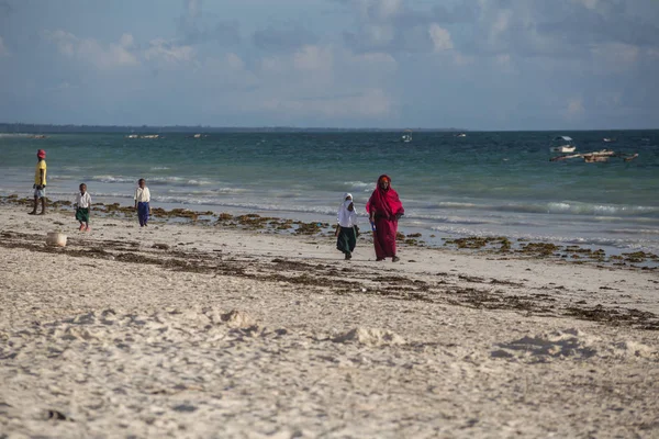 2018.02.21, Kiwengwa, Tanzanya. Bir grup genç insan sahilde yürüyüş. Öğrenciler eve gidiyor. Çocuklar eve gidiyor.