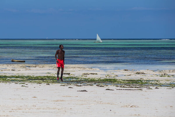 2018.02.21, Kiwengwa, Tanzania. Travel around Tanzania. An attractive African men playing football on the beach on background of blue sky and ocean.