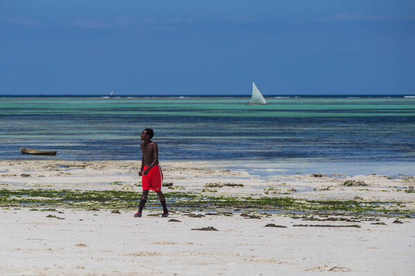 2018.02.21, Kiwengwa, Tanzania. Travel around Tanzania. An attractive African men playing football on the beach on background of blue sky and ocean.