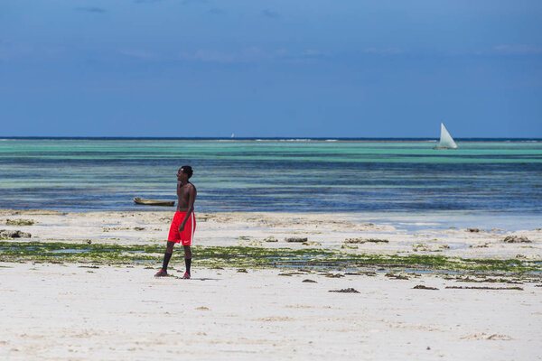 2018.02.21, Kiwengwa, Tanzania. Travel around Tanzania. An attractive African men playing football on the beach on background of blue sky and ocean.