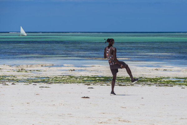 2018.02.21, Kiwengwa, Tanzania. Travel around Tanzania. An attractive African men playing football on the beach on background of blue sky and ocean.