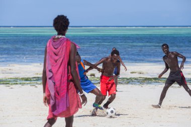 2018.02.21, Kiwengwa, Tanzanya. Tanzanya seyahat. Bir grup çekici bir Afrika adam arka plan mavi gökyüzü ve okyanus plaj futbol oynamak. Zanzibar eğlence.