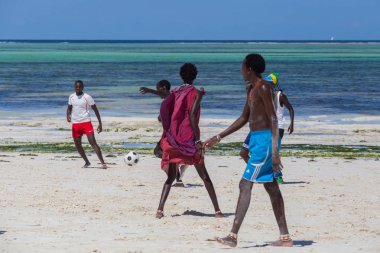 2018.02.21, Kiwengwa, Tanzanya. Tanzanya seyahat. Bir grup çekici bir Afrika adam arka plan mavi gökyüzü ve okyanus plaj futbol oynamak. Zanzibar eğlence.