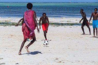 2018.02.21, Kiwengwa, Tanzanya. Tanzanya seyahat. Bir grup çekici bir Afrika adam arka plan mavi gökyüzü ve okyanus plaj futbol oynamak. Zanzibar eğlence.