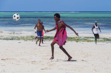 2018.02.21, Kiwengwa, Tanzanya. Tanzanya seyahat. Bir grup çekici bir Afrika adam arka plan mavi gökyüzü ve okyanus plaj futbol oynamak. Zanzibar eğlence.