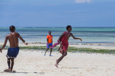 2018.02.21, Kiwengwa, Tanzanya. Tanzanya seyahat. Bir grup çekici bir Afrika adam arka plan mavi gökyüzü ve okyanus plaj futbol oynamak. Zanzibar eğlence.