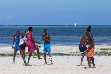 2018.02.21, Kiwengwa, Tanzanya. Tanzanya seyahat. Bir grup çekici bir Afrika adam arka plan mavi gökyüzü ve okyanus plaj futbol oynamak. Zanzibar eğlence.