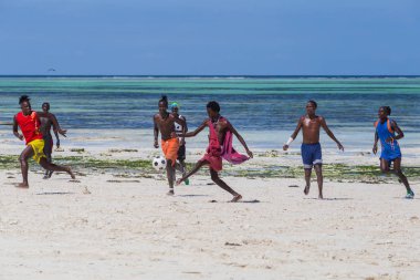 2018.02.21, Kiwengwa, Tanzanya. Tanzanya seyahat. Bir grup çekici bir Afrika adam arka plan mavi gökyüzü ve okyanus plaj futbol oynamak. Zanzibar eğlence.