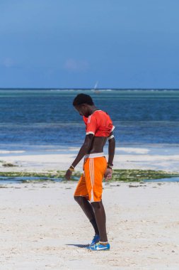 2018.02.21, Kiwengwa, Tanzanya. Tanzanya seyahat. çekici bir Afrika erkek giyim spor giyim ve arka plan mavi gökyüzü ve okyanus üzerinde deniz kenarında yürüyüş. Zanzibar eğlence.