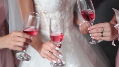 Gelin ve arkadaşları gözlük pembe şampanya ile düzenliyoruz. Gül düğün bardaklarda şarap. Kızlar pembe şarap içmek istiyorum. Gelin kızlar ile pembe şampanya içiyor.