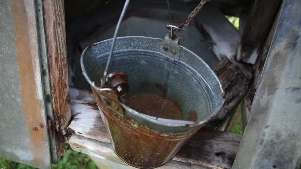 一种古老的木制井 拥有纯净的天然饮用水 一个男人正在用铝杯里的水桶拾水 — 图库视频影像