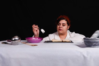 Öğrenci siyah arka planda pasta hazırlıyor.