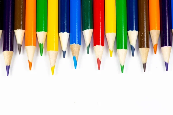Color pencils lined up in a row against a white background.